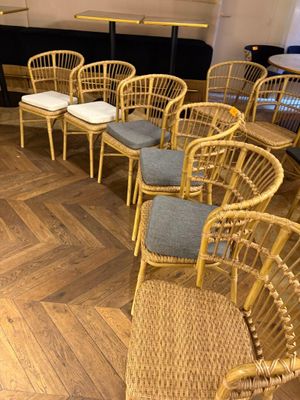 de nombreuses chaises et tables dans une pièce au sol en parquet