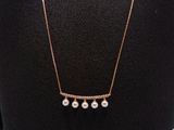 a gold necklace with three pearls on a mannequin neck