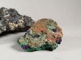 two different colored rocks sitting next to each other on a white surface