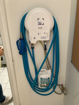 a blue hose attached to the wall of a bathroom