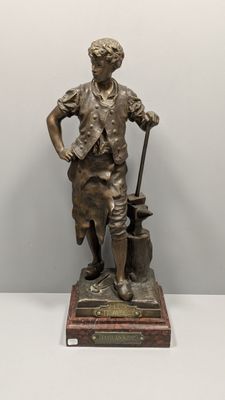 statue en bronze représentant un garçon avec un sac et un bâton