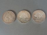 three different coins are shown on a gray surface