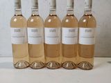 six bouteilles de vin blanc sont alignées sur une table