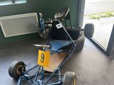 a go kart in the garage of a car repair shop