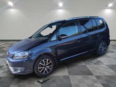 une Volkswagen Touran bleue garée sur un sol en carrelage à damier