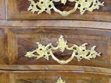 a wooden chest of drawers with gold decorations on it