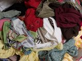 a large pile of clothes sitting on top of a bed