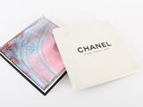 une boîte blanche contenant un foulard rose et bleu