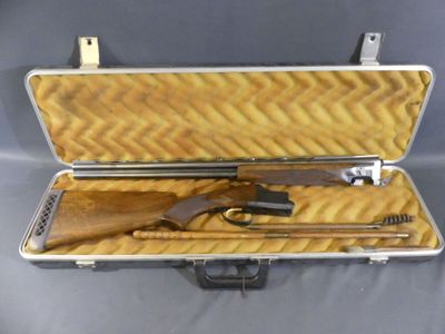 an open case with a gun and other items inside of it