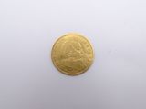 a close up of a gold coin on a white surface