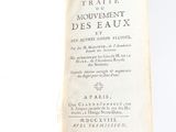 un livre ouvert sur une surface blanche, dont le titre est en français