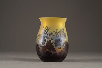 a yellow vase sitting on a table on a gray surface