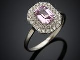 a pink sapphire and diamond ring on a black background