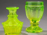 two green glass vases sitting next to each other on a table