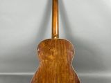 une vieille guitare en bois posée sur une surface blanche