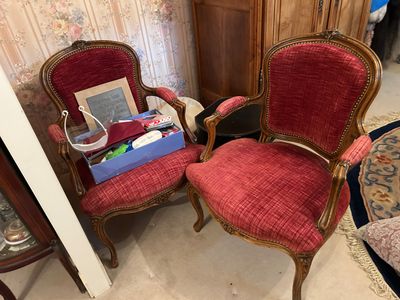deux fauteuils rouges dans un salon, à côté d'une commode