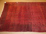a red rug on the floor with a brown background