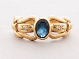 an image of a gold ring with a blue topaz stone