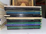 many books stacked on top of each other on a table