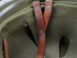 a close up of a military helmet with a leather strap