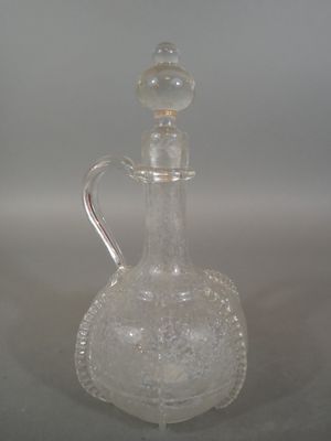 a clear glass bottle with a silver handle on a table