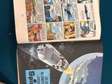 someone is holding a comic book open on a blue surface