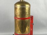 an old brass fire extinguisor with a red handle on a white background