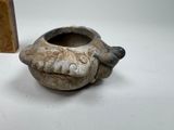 a small vase with a face on it next to a small box