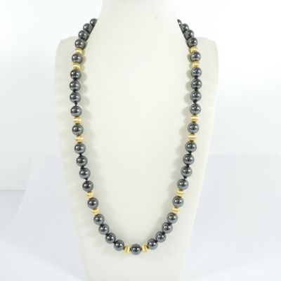 a black and gold beaded necklace on a mannequin