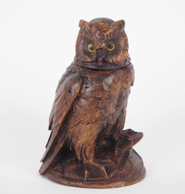 an owl statue sitting on top of a wooden base