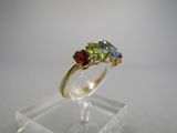 gros plan d'une bague en or avec des pierres multicolores