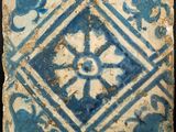 a close up of a blue and white tile on a black surface