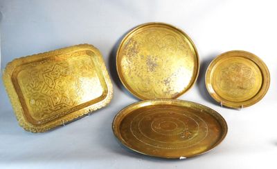 three brass trays and a plate on a white background