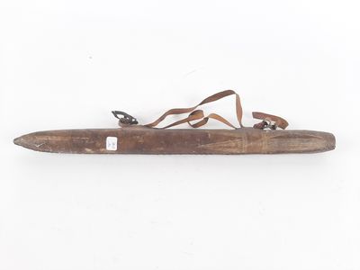 an old wooden knife with a leather strap hanging from it ' s handle