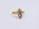 a close up of a gold ring with pearls and a pink stone