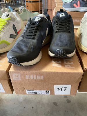 several pairs of running shoes sitting on top of boxes in a store