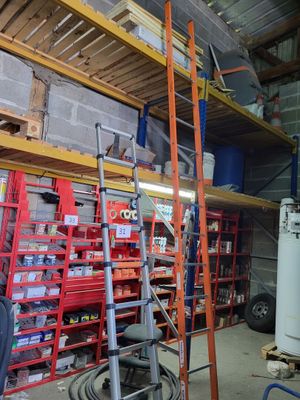 a man that is standing next to a ladder in a garage