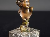 un buste de femme en bronze sur un socle en marbre