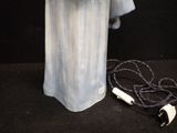 a blue vase with a light on it next to a cord