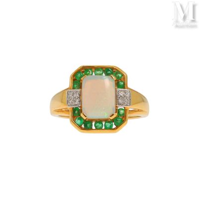 un gros plan d'une bague sertie d'un oplite et d'une émeraude