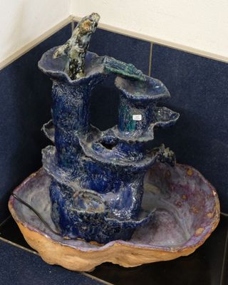 a blue bowl with a bird perched on top of it