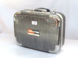 une valise argentée posée sur une surface blanche