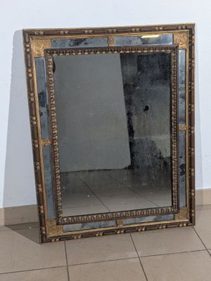 un miroir posé sur le sol à côté d'un mur