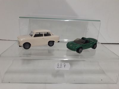 two toy cars that are on display in a glass case