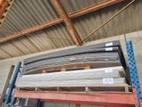 a large stack of steel bars on a pallet in a warehouse