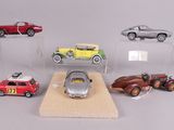 five different model cars on display in a display case