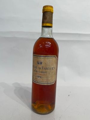 an old bottle of wine sitting on top of a white table