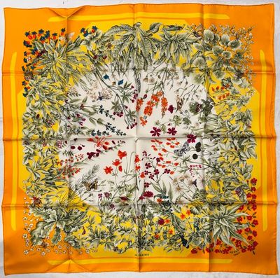 an orange and yellow square scarf with a floral design