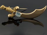 une broche en or ornée d'un dragon et d'une épée