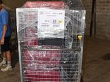 un homme debout à côté d'un chariot rempli de bagages